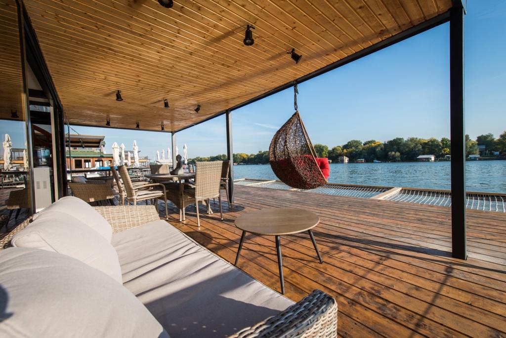 SOfa and hammock chair on terrace next to river